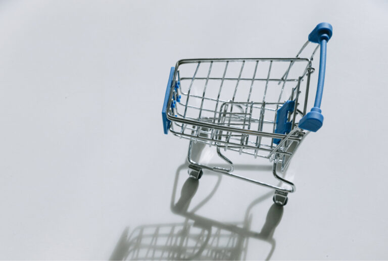 Empty shopping cart on a white surface, isolated with clipping path. Minimal concept.